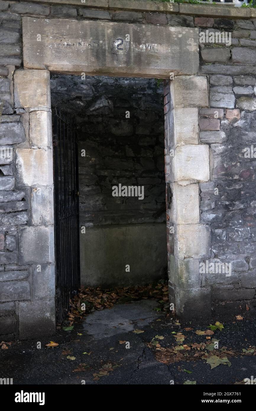 Septembre 2021 - porte sombre / ouverture dans un mur menant à un ensemble de marches dans la ville de Bristol, Angleterre, Royaume-Uni. Banque D'Images