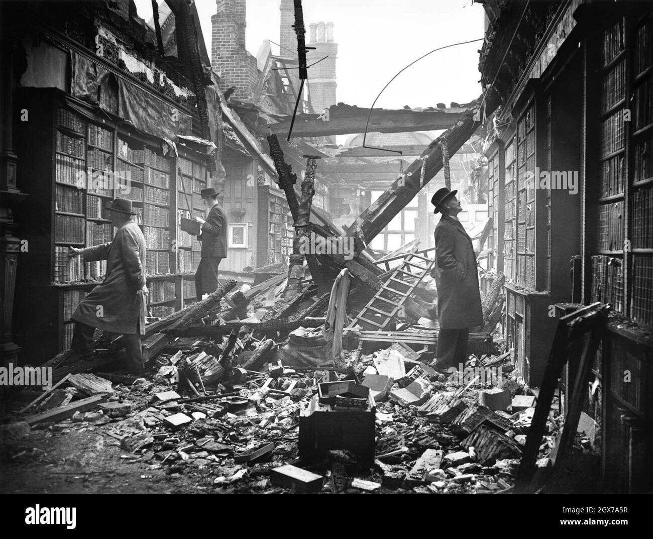 Les gens qui se sont mis à parcourir les étagères de la bibliothèque Holland House, très endommagée, à Kensington, à Londres, pendant le Blitz. Banque D'Images