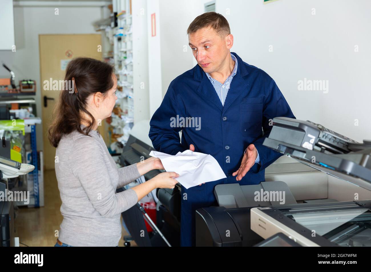 Un employé de bureau se plaint auprès du réparateur d'une imprimante  défectueuse Photo Stock - Alamy