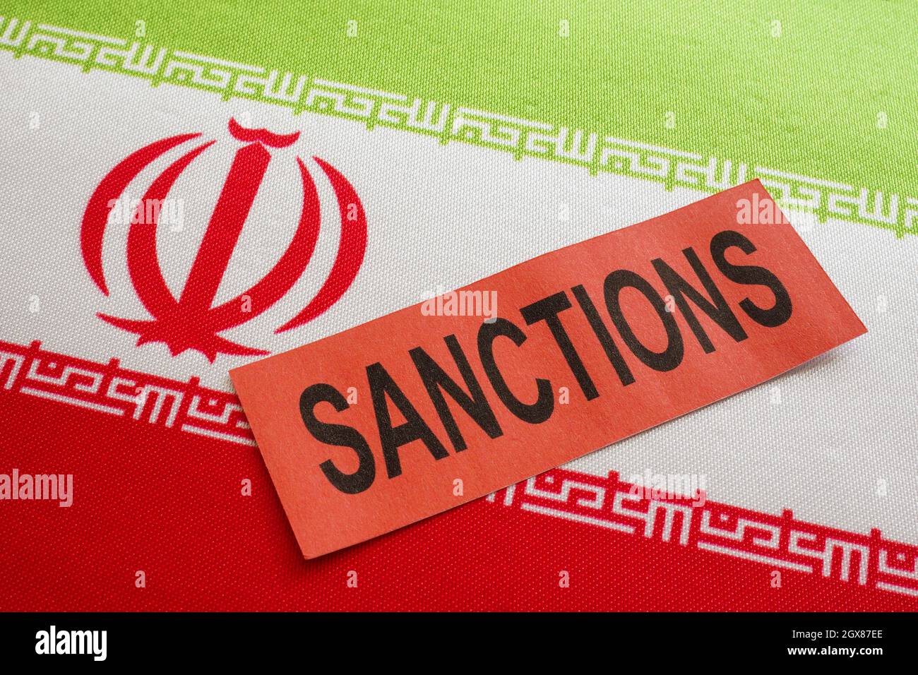 Le drapeau de l'Iran et le mot sanctions sur un morceau de papier. Banque D'Images