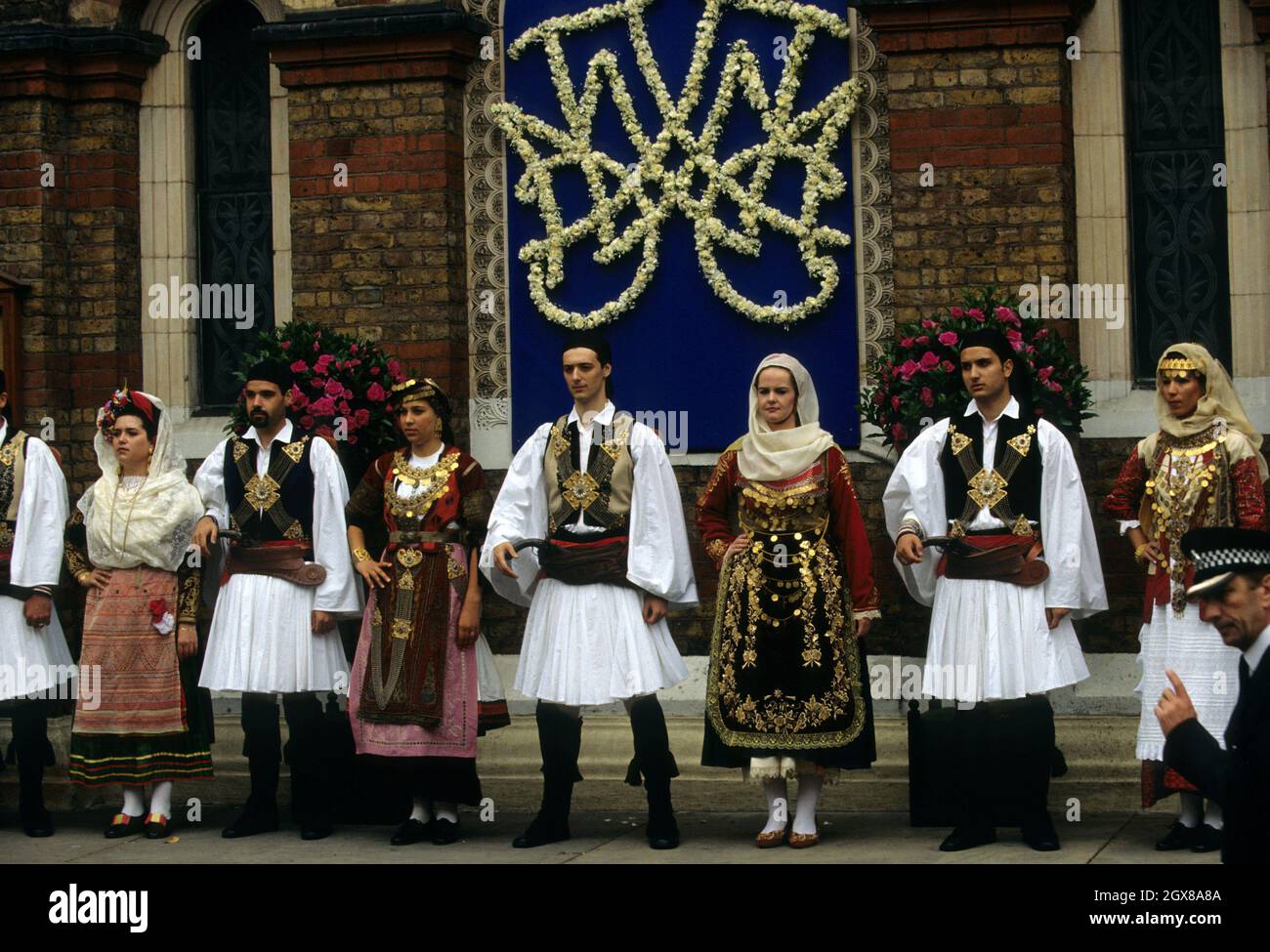 Une troupe de danse grecque traditionnelle se trouve à l'extérieur de la cathédrale Sainte-Sophie, à Londres, après le mariage de Pavlos, prince héritier de Grèce et de Marie-Chantal Miller Banque D'Images