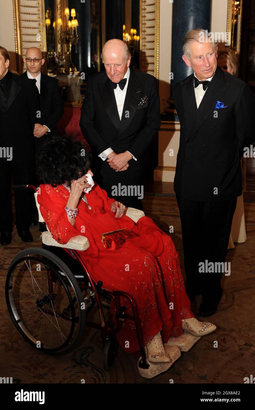 Prince Charles, Prince de Galles, Lord Rowe-Beddoe, président du Royal Welsh College (R) et actrice Dame Elizabeth Taylor, assis en fauteuil roulant, bavardent ensemble lors d'une soirée de gala au Royal Welsh College à Buckingham Palace à Londres, le 29 avril 2010. Banque D'Images