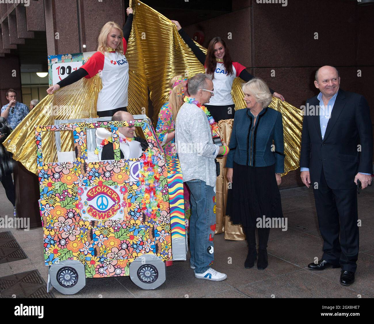 Camilla, la duchesse de Cornwall rencontre des travailleurs vêtus d'une robe de fantaisie « hippie » lorsqu'elle visite la Journée de la Charité de l'ICAP à Londres le 3 décembre 2013. Banque D'Images
