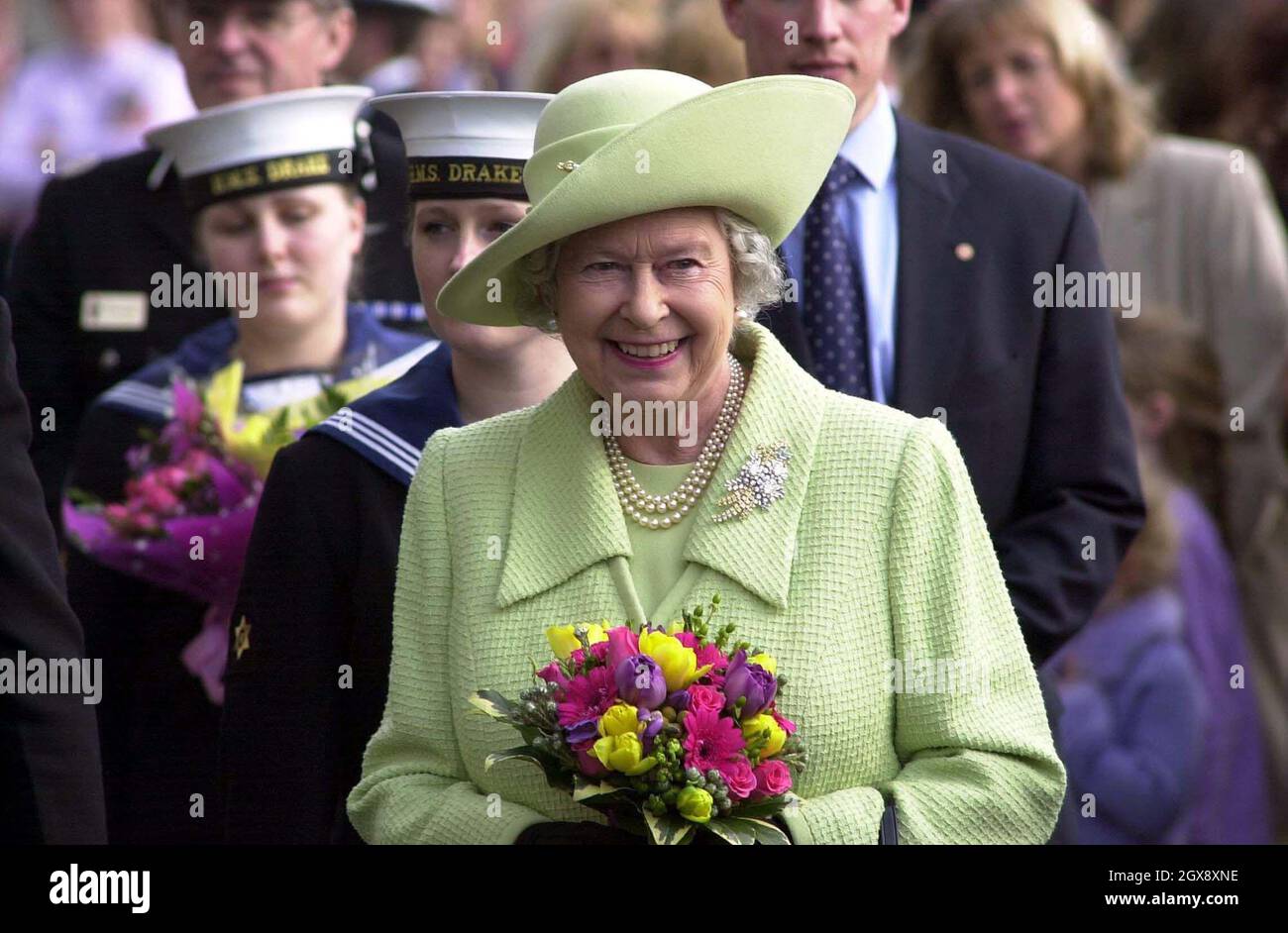 La reine Elizabeth II de Grande-Bretagne est accueillie lors de sa visite à la base navale de Devonport, Plymouth, le lundi 24 mars 2003.La Reine a rencontré des familles de ceux qui servaient dans le golfe, où elle a bavardé avec des dizaines de femmes, d'enfants, de mères et de pères.Le duc d'Édimbourg, qui est arrivé séparément, a également passé du temps à parler aux familles.Demi-longueur, chapeau, royals, souriant, fleurs - Anwar Hussein/allaction.co.uk Banque D'Images