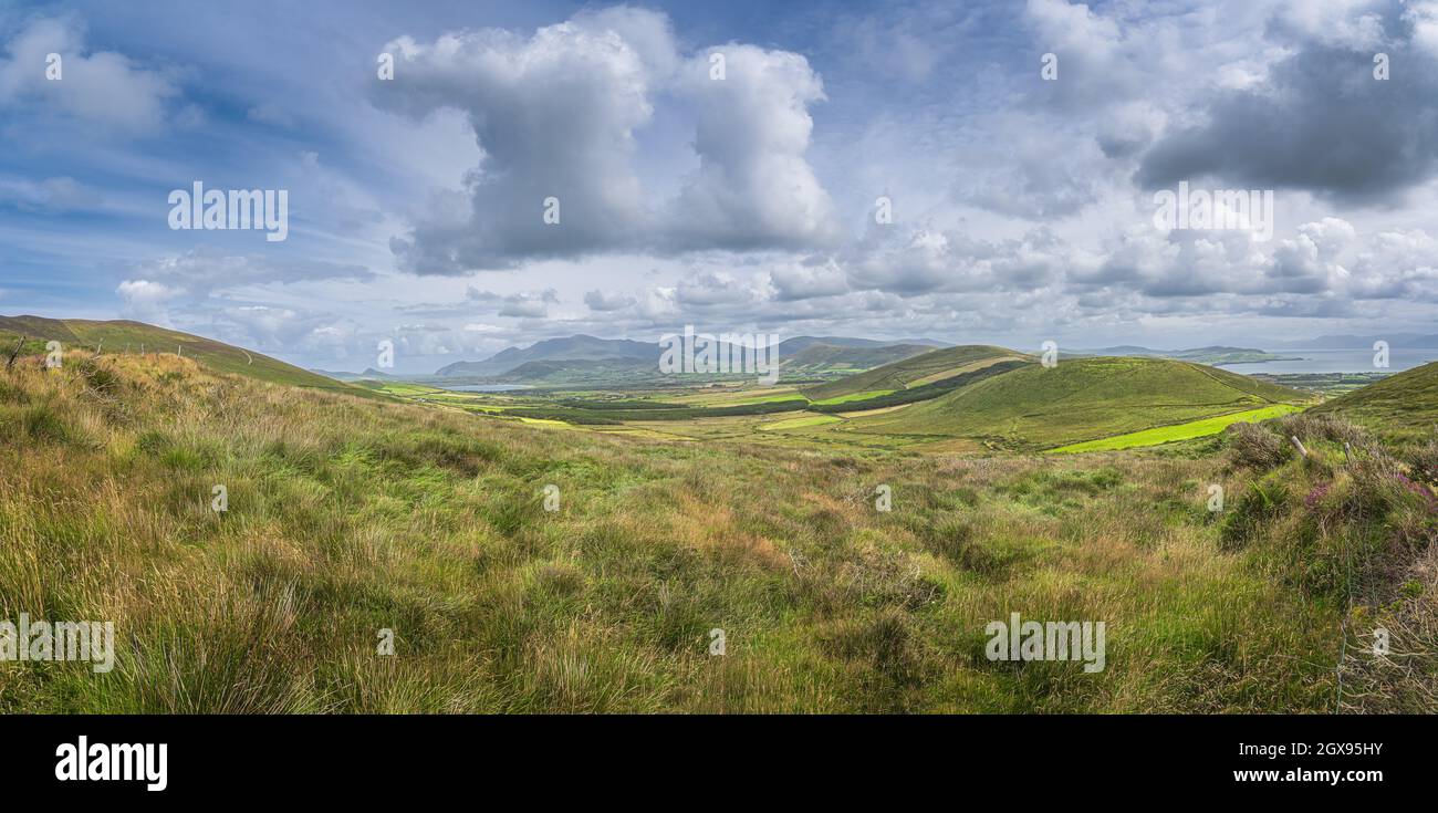 Grand panorama avec vallée, champs verdoyants, forêt et lac, entouré de collines et de montagnes, péninsule de Dingle, Wild Atlantic Way, Kerry, Irlande Banque D'Images