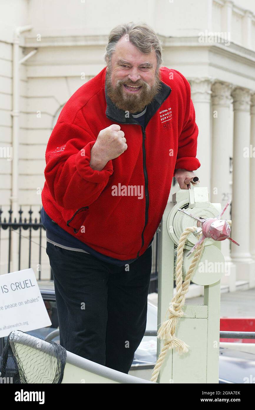 Brian Blessed pose à côté de lifesize réplique harpon monté sur une plate-forme qui est destinée à l'ambassade de Norvège. Banque D'Images