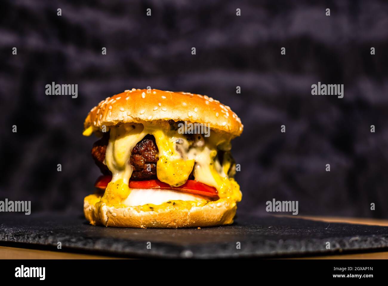 Gros plan un cheeseburger au bœuf frais et savoureux avec du fromage fondu isolé sur fond noir Banque D'Images