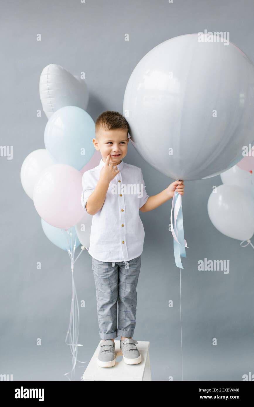 Fête de révélation de genre. Un enfant de quatre ans tient un ballon entre ses mains pour découvrir le sexe de l'enfant à naître dans la famille. Anniversaire de l'enfant Banque D'Images