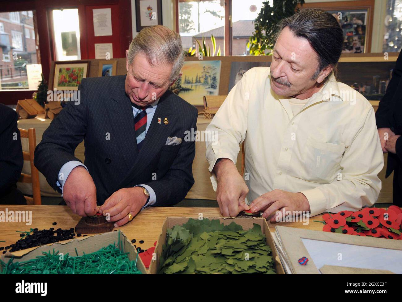 Le Prince Charles, Prince de Galles, patron de la Société de protection mentale ex-Services, tente de faire un coquelicot alors qu'il visite la Maison Tyrwhit à Leatherhead.La Société de bien-être mental ex-Services, combat stress, est la seule organisation caritative spécialisée dans l'aide à ceux de tous les rangs des Forces armées et de la Marine marchande. Banque D'Images