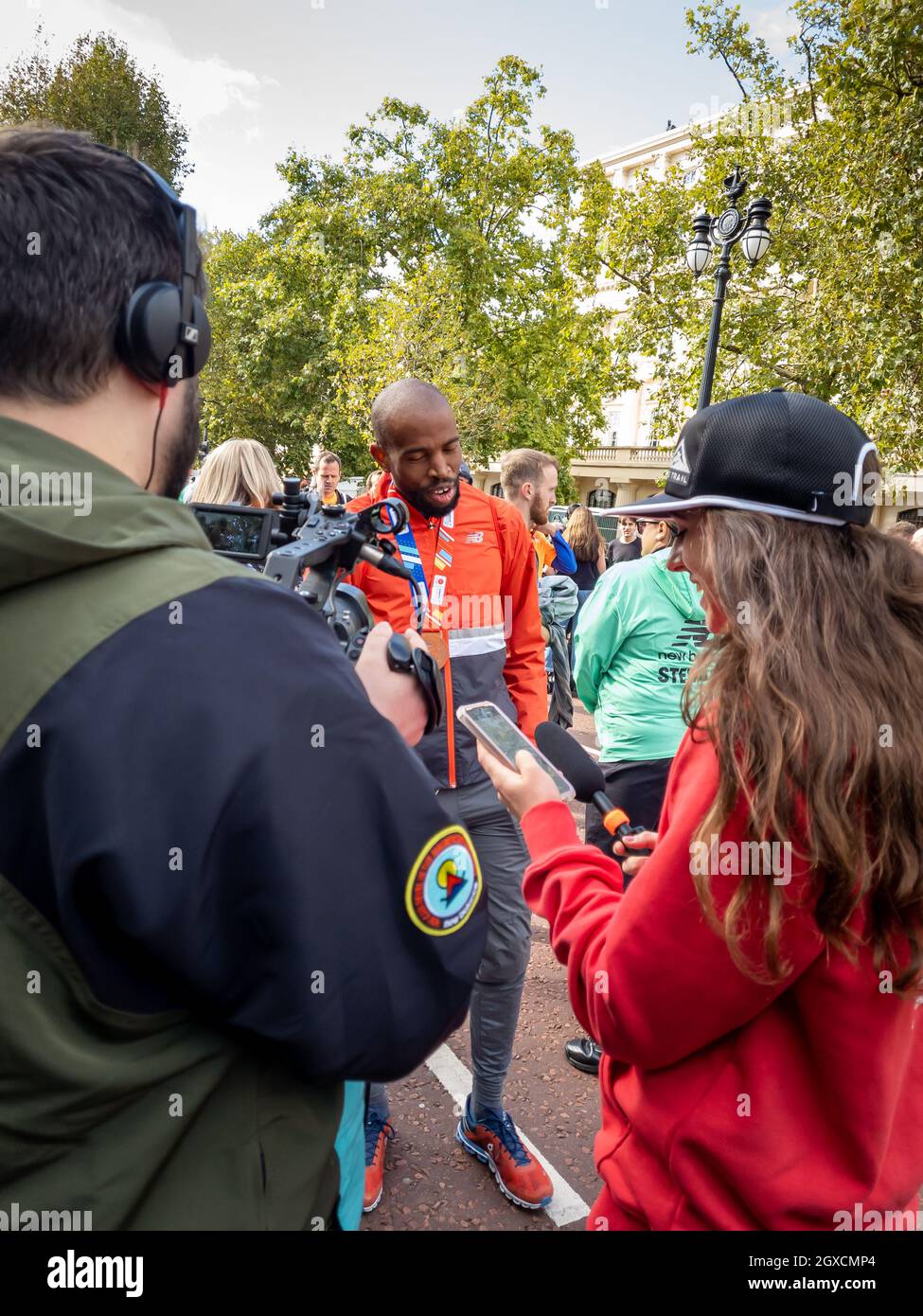 Londres. ROYAUME-UNI. 10.03.2021. Une équipe de presse interrogeant un athlète au Pall Mall à la fin du Marathon de Londres. Banque D'Images