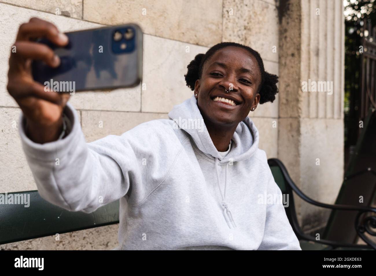 Souriant Afro-américaine femme avec piercing prenant autoportrait avec smartphone Banque D'Images