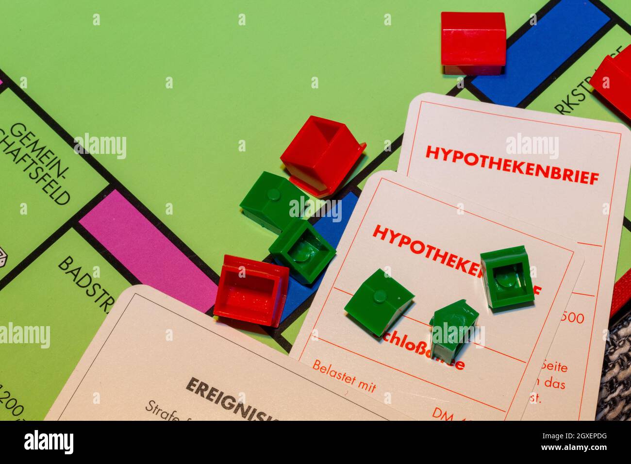 Image symbole de l'immobilier : jeu de monopole avec maisons renversées et notes hypothécaires Banque D'Images