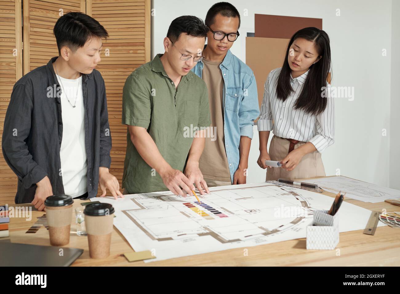 Grand groupe d'architectes discutant de l'esquisse de construction et du choix de la couleur à partir de la palette Banque D'Images