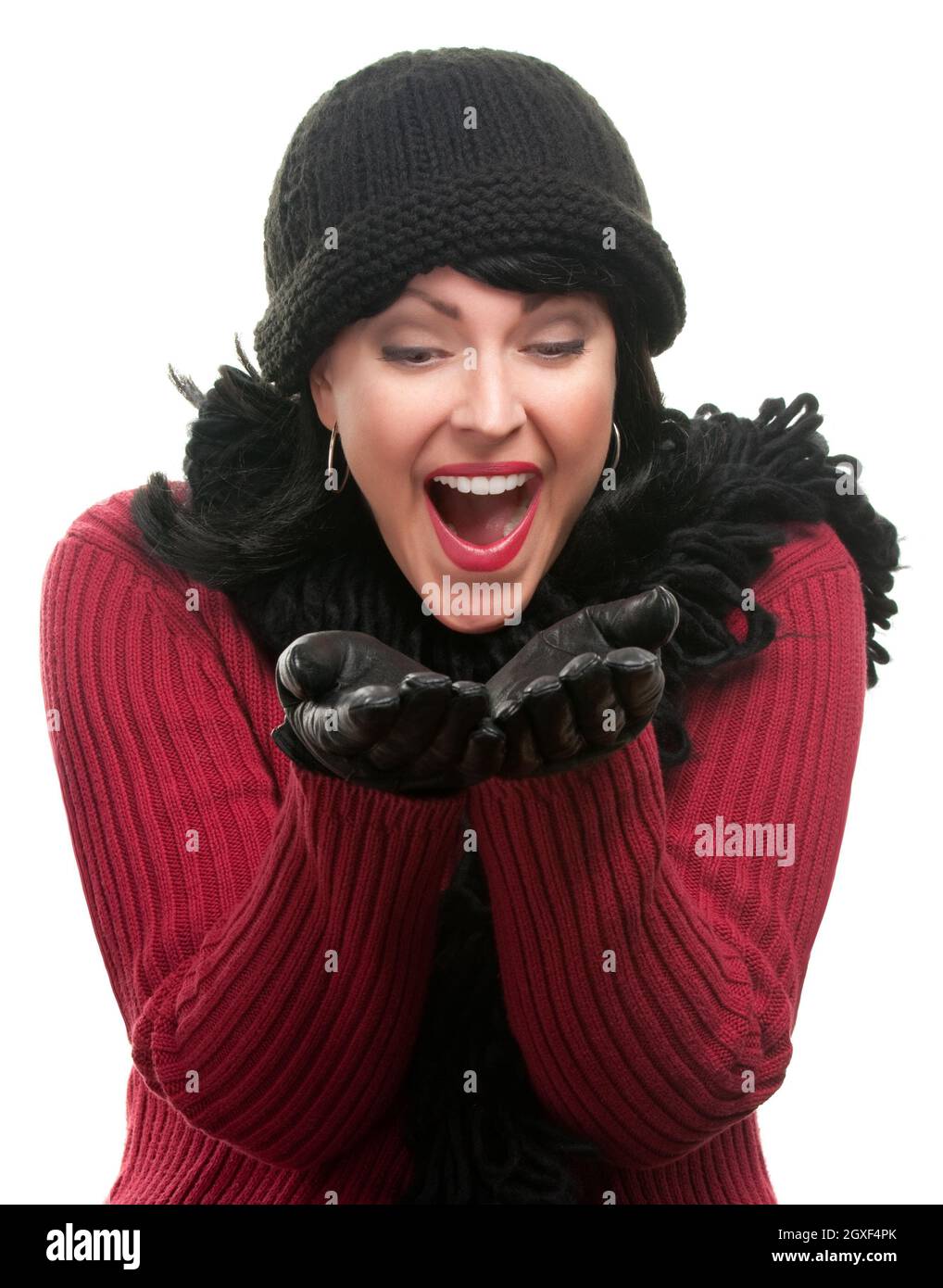Une femme excitée en vêtements d'hiver tient ses mains isolées sur un fond blanc. Banque D'Images
