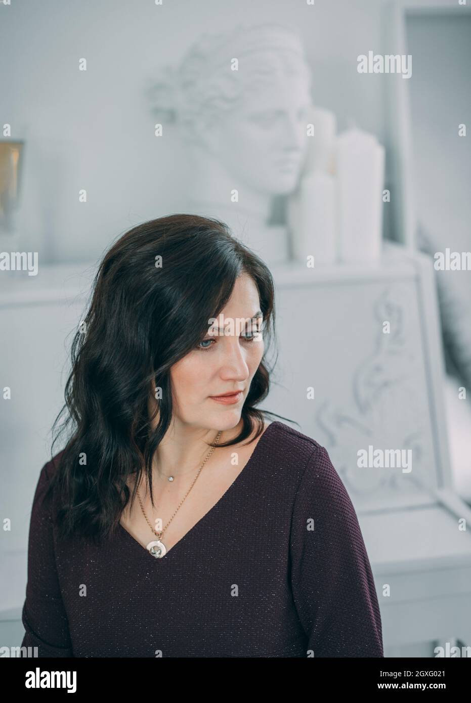 Beau portrait jeune femme pensant dans un intérieur blanc. Bonne Année. Banque D'Images