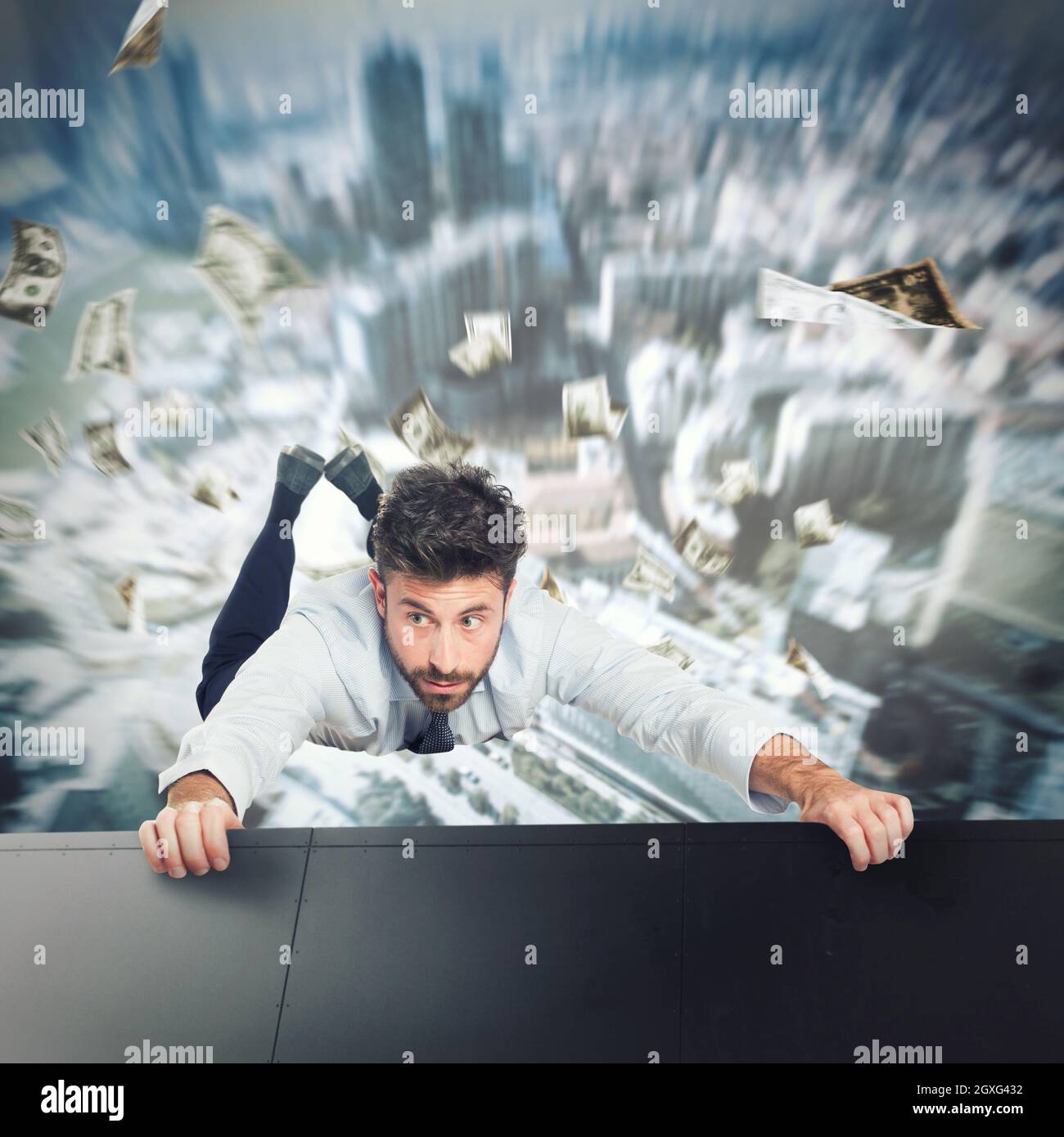 Homme d'affaires tenant sur le bord d'un gratte-ciel pour éviter de tomber Banque D'Images