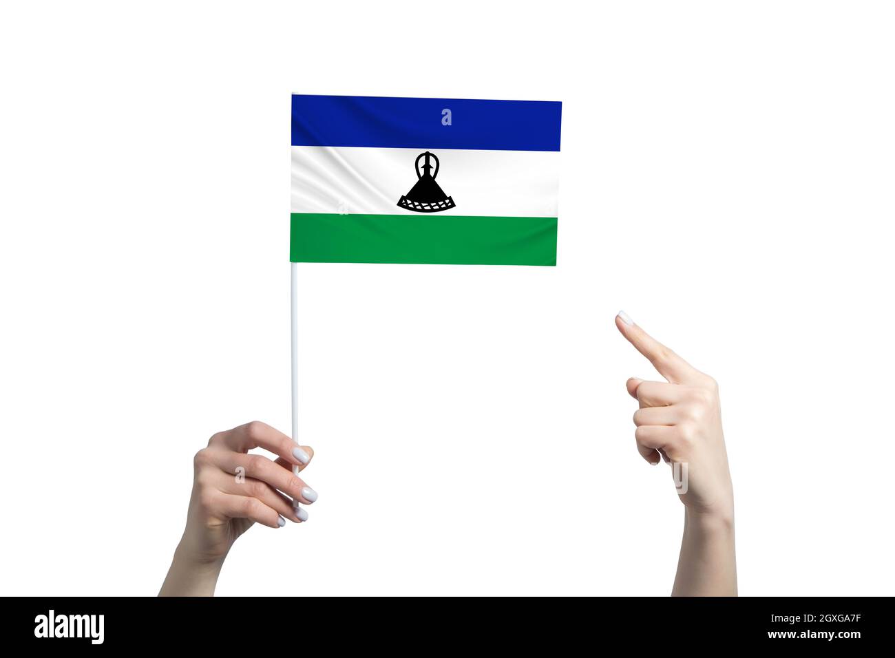 Une belle main femelle porte un drapeau du Lesotho auquel elle montre le doigt de son autre main, isolé sur fond blanc. Banque D'Images