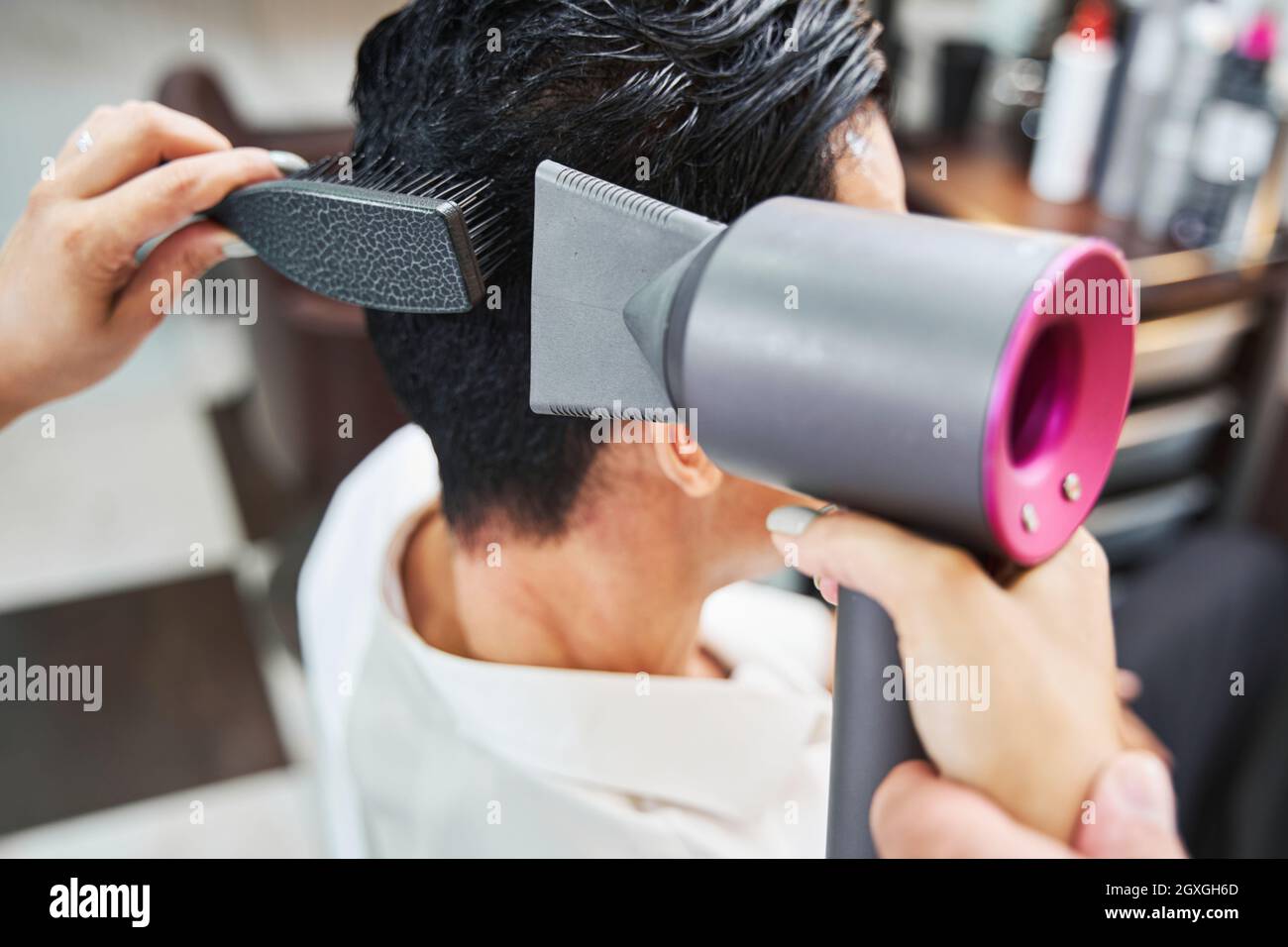 Sèche-cheveux soufflant de l'air chaud sur les cheveux mâles Photo Stock -  Alamy