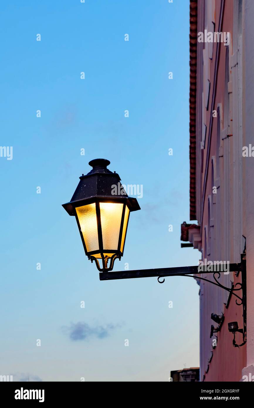 De vieilles lanternes métalliques sur le mur d'une maison coloniale avec le ciel en arrière-plan pendant la nuit tombée dans le quartier Pelourinho dans la ville de Salva Banque D'Images