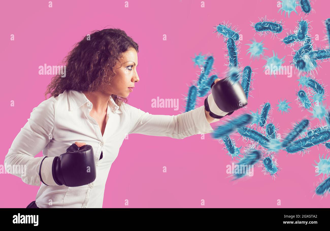Une femme agressive combat avec des gants de boxe contre les bactéries Banque D'Images