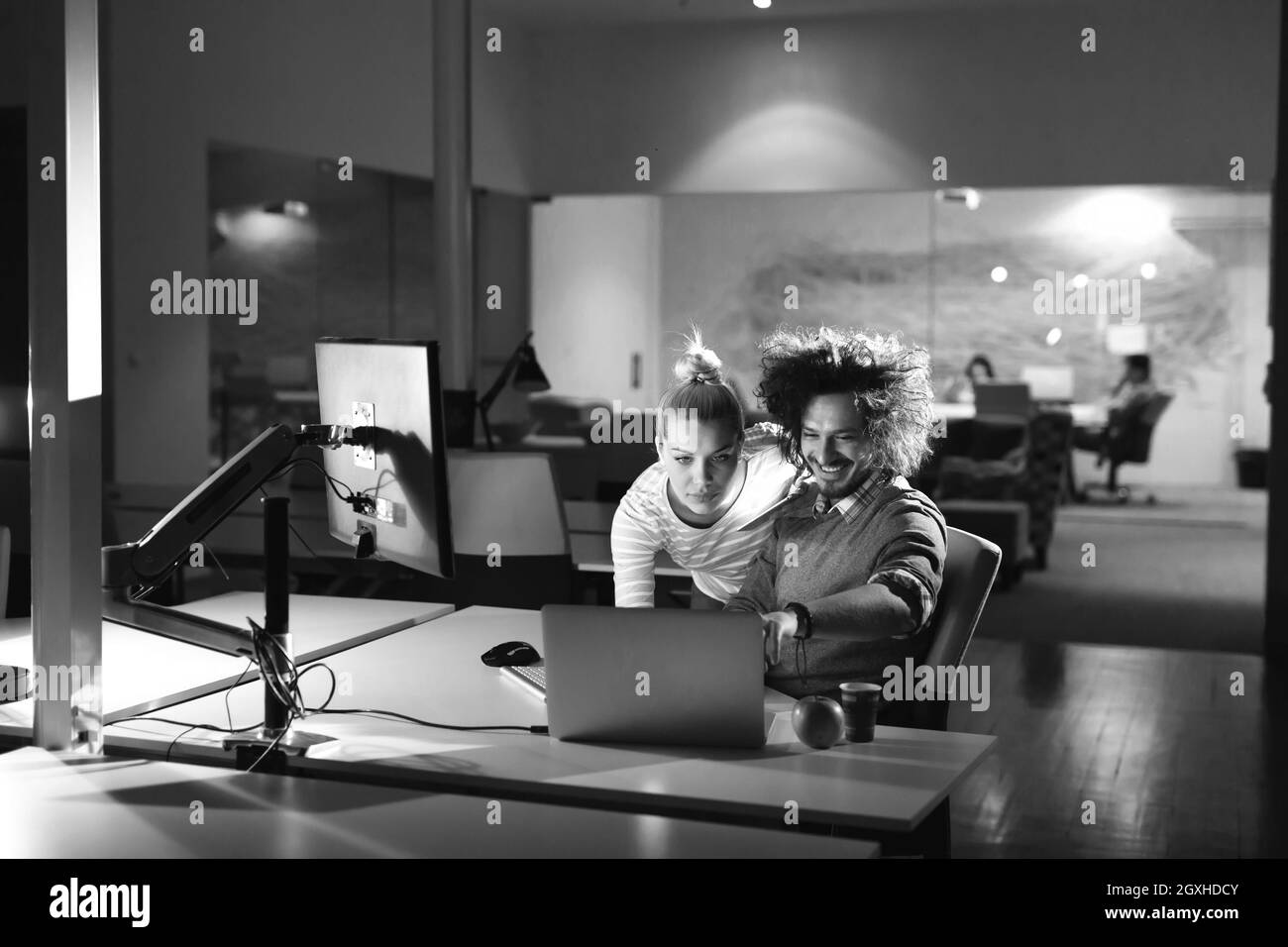 Deux jeunes designers travaillent sur un nouveau projet dans l'office de nuit à l'aide de la technologie moderne Banque D'Images