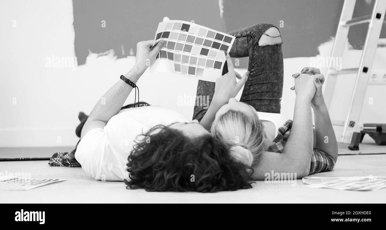 Happy young couple relaxing après peinture une pièce de leur nouvelle maison à l'étage Banque D'Images