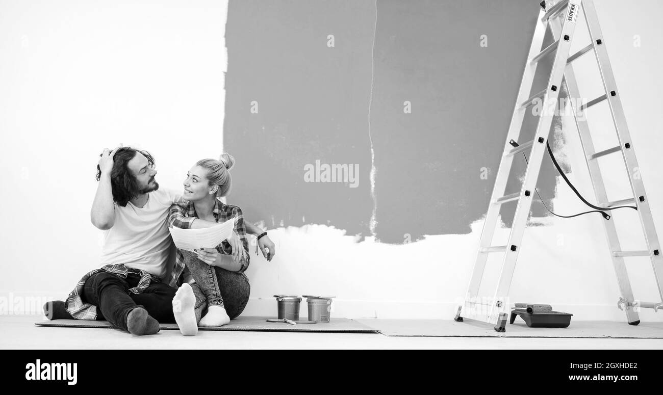 Happy young couple relaxing après peinture une pièce de leur nouvelle maison à l'étage Banque D'Images