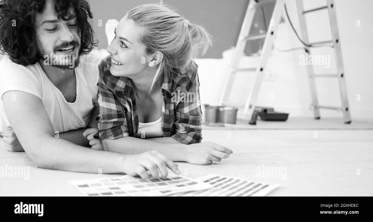 Happy young couple relaxing après peinture une pièce de leur nouvelle maison à l'étage Banque D'Images