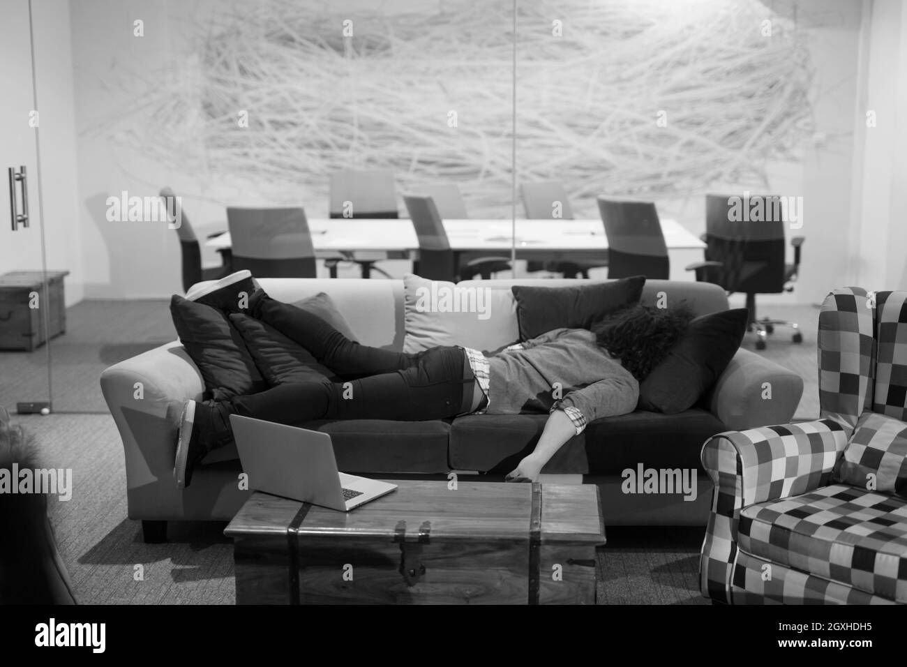 Un jeune businessman dormir sur un canapé pendant une pause de travail dans un bureau de création Banque D'Images