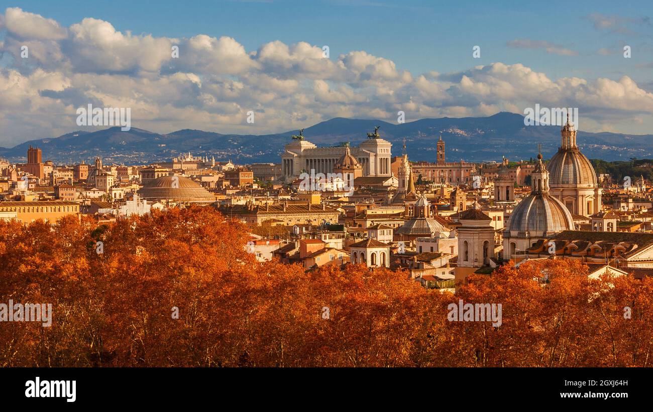Automne à Rome. Vue sur la ligne d'horizon du centre historique juste avant le coucher du soleil avec les anciens monuments, les dômes baroques et les feuilles rouges Banque D'Images