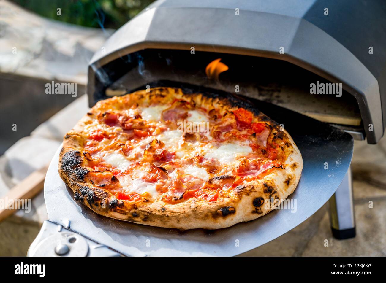Faire de la pizza maison dans un four à pizza à gaz portable haute température. La délicieuse pizza est cuite dans un four à gaz pour la pizza napolitaine maison. Spéi Banque D'Images Faire de la pizza maison dans un four à pizza à gaz portable haute température. La délicieuse pizza est cuite dans un four à gaz pour la pizza napolitaine maison. Spéi Banque D'Images