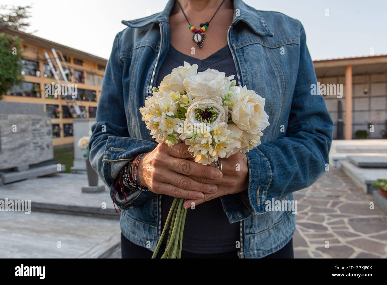 Femme apporte des fleurs au cimetière à l'occasion de la fête de commémoration des morts, ou jour des morts Banque D'Images
