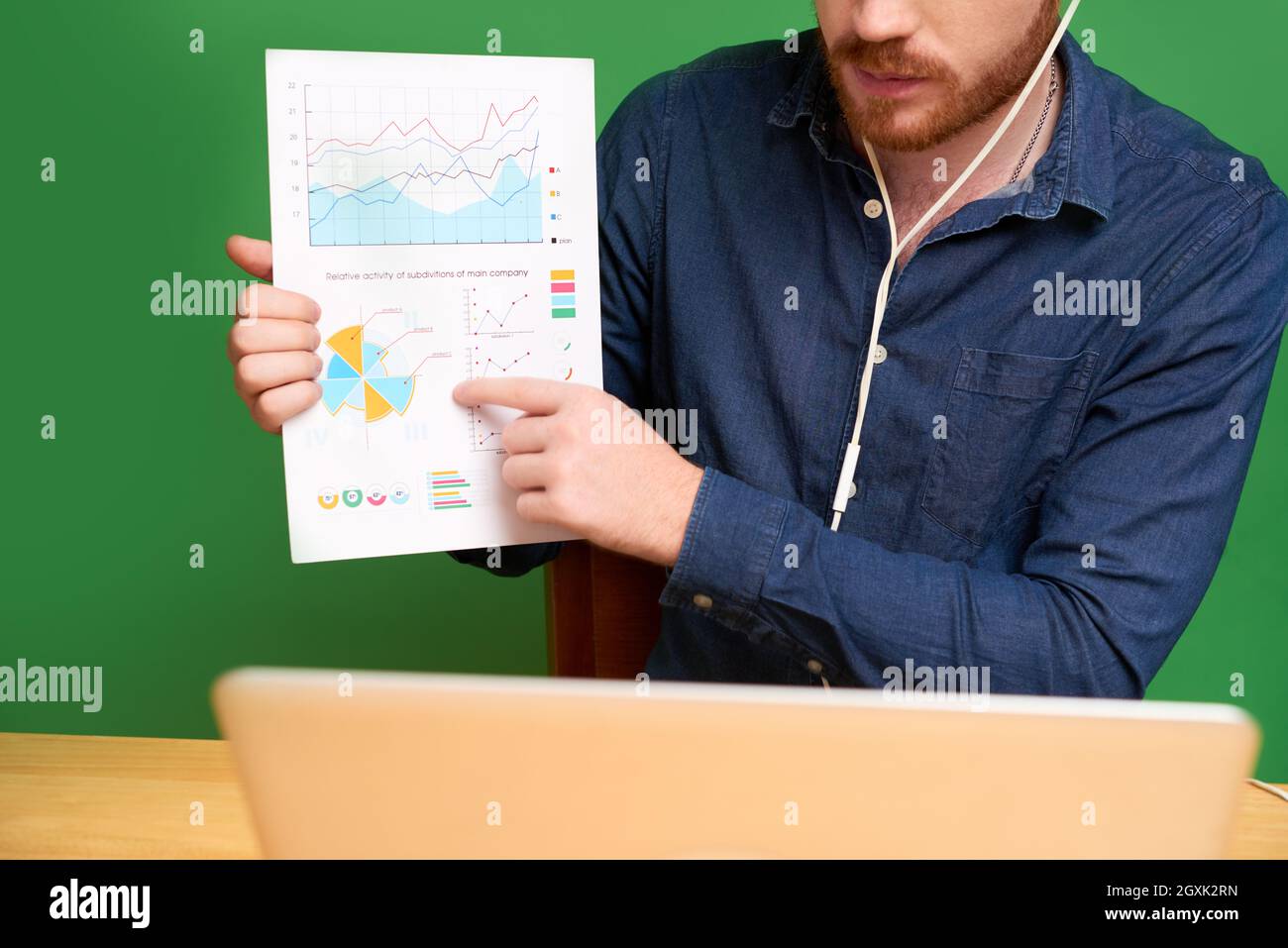 Gros plan du consultant financier dans les écouteurs pointant vers le graphique tout en expliquant les données statistiques au client et en lui parlant par vidéoconférence Banque D'Images