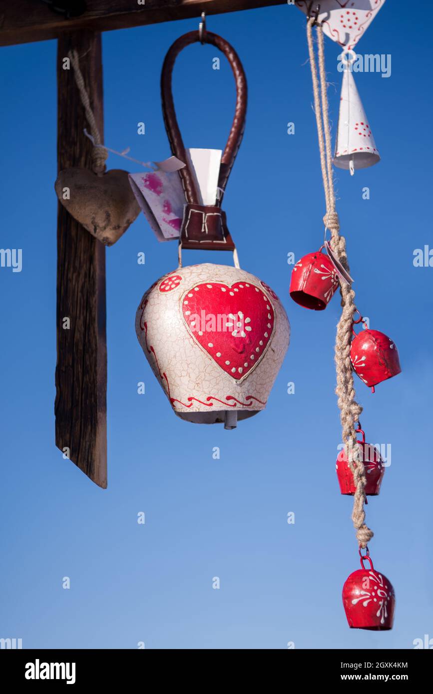 cloches de vache traditionnelles comme décoration de maison ou cadeau accroché sur une poutre en bois avec ciel bleu en arrière-plan Banque D'Images