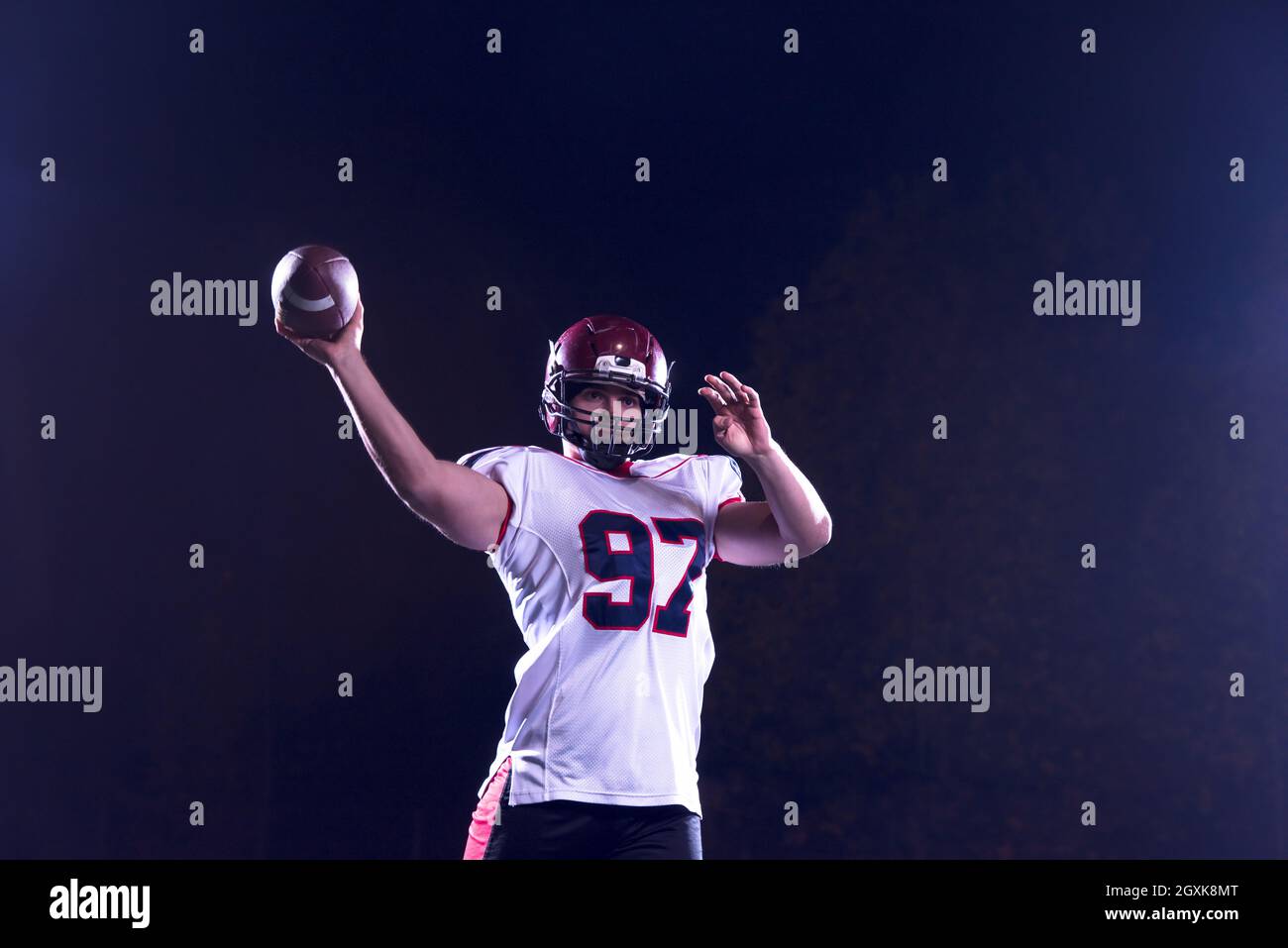 Le football américain lanceur ballon de rugby sur fond noir Photo Stock -  Alamy