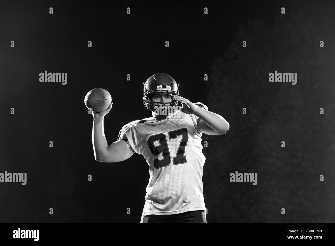 Le football américain lanceur ballon de rugby sur fond noir Photo Stock -  Alamy