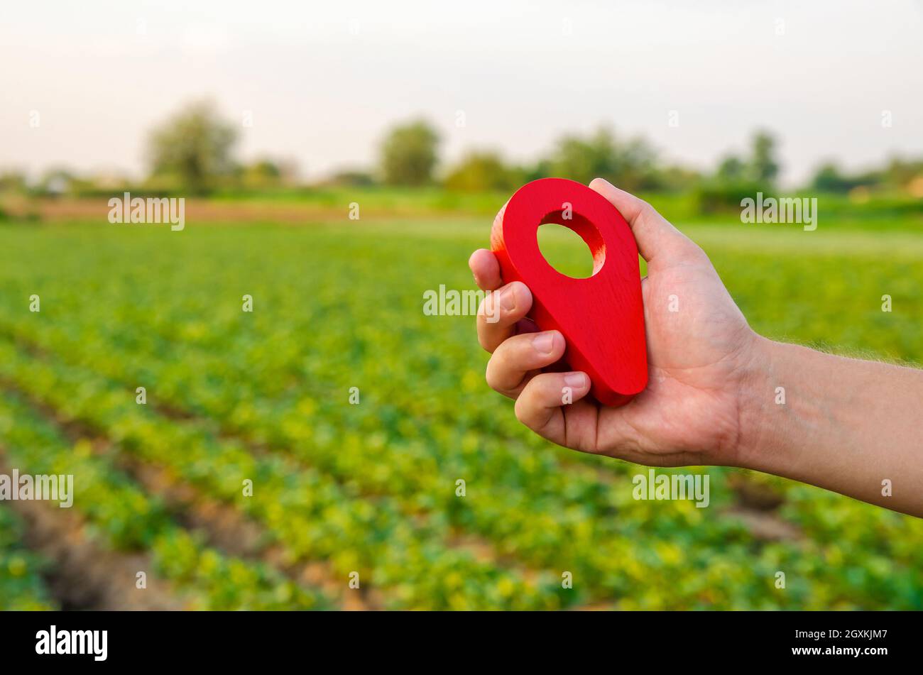 Broche d'emplacement rouge sur le champ de ferme. Achat et vente sur le marché foncier. Service de démarcation de tracé de limite. Réglementation juridique de la propriété. Agriculture et ag Banque D'Images