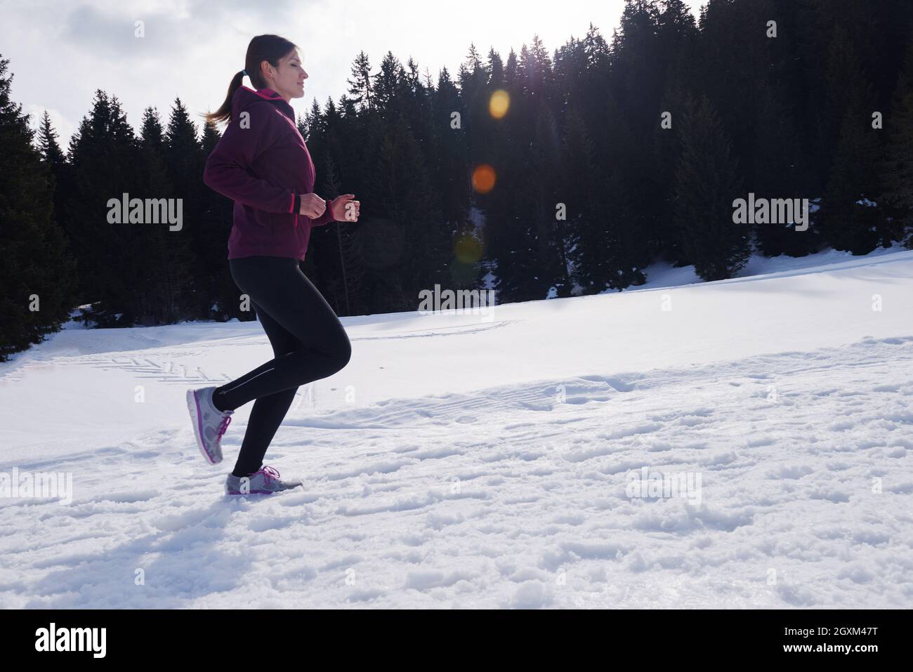 Yougn woman jogging en plein air, sur la neige en forêt, l'hiver et des loisirs sains de style de vie Banque D'Images