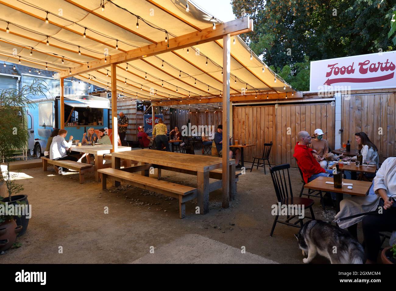 Des camions gastronomiques et un espace sur le patio niché dans une ruelle derrière un bar-salon, 3634 se Division St, Portland, Oregon. Banque D'Images