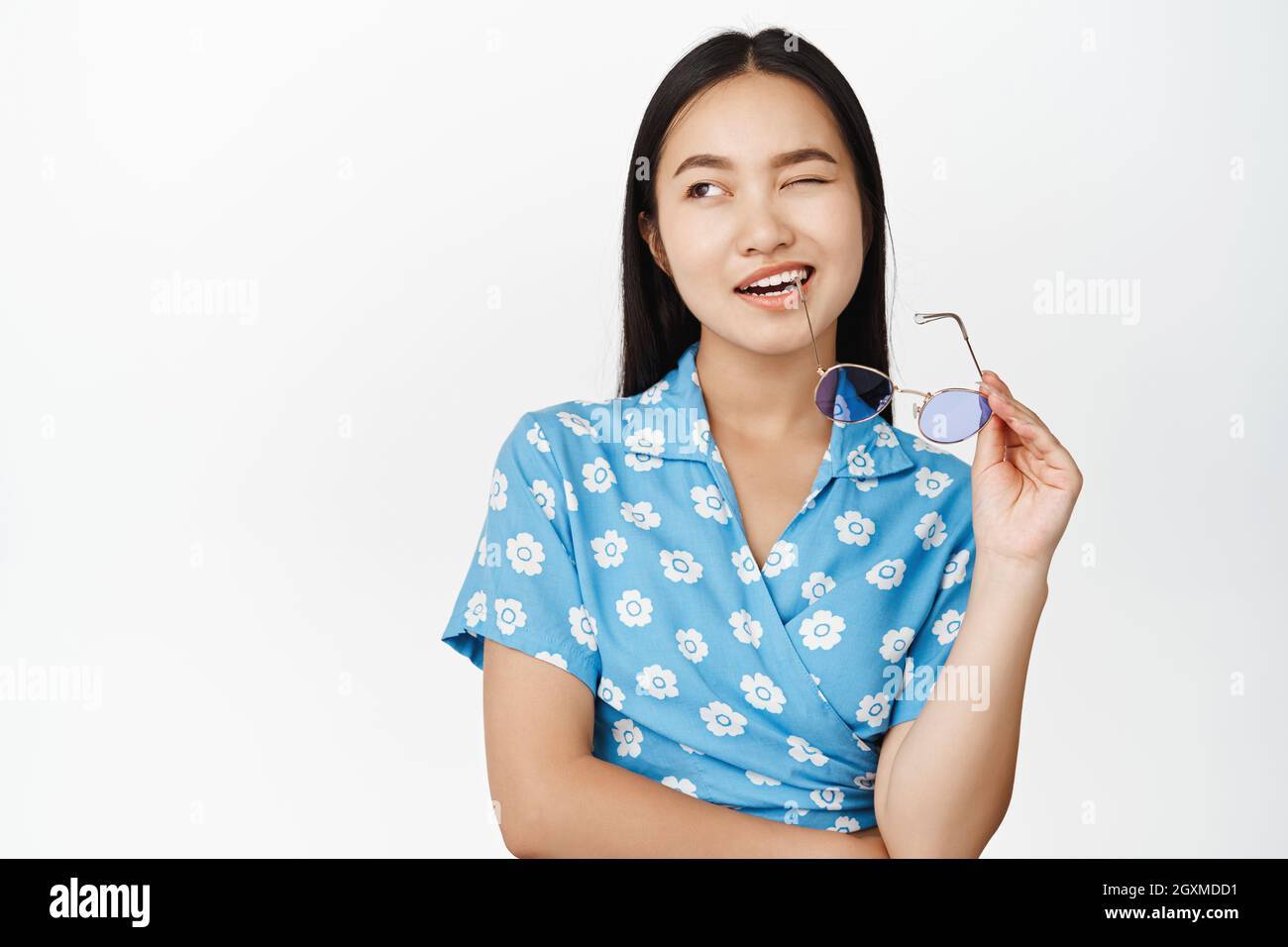 Portrait de la belle fille asiatique moderne bite temple de lunettes de  soleil, wencing et sourire avec confiance, debout sur fond blanc Photo  Stock - Alamy