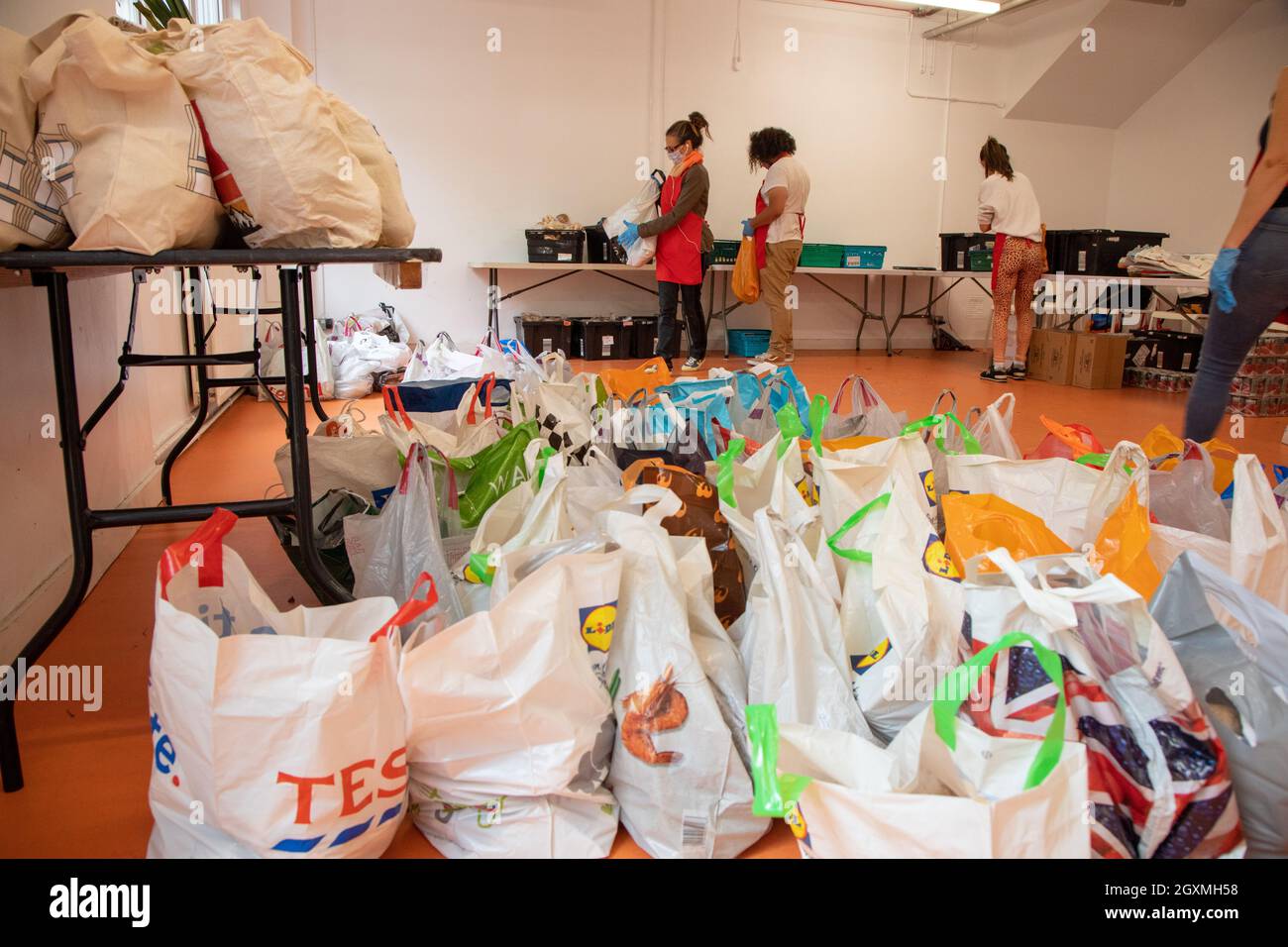Des bénévoles dans une banque alimentaire triant des caisses de nourriture en vue des distribuer aux membres de la communauté locale dans le besoin. Ils sont au G Banque D'Images