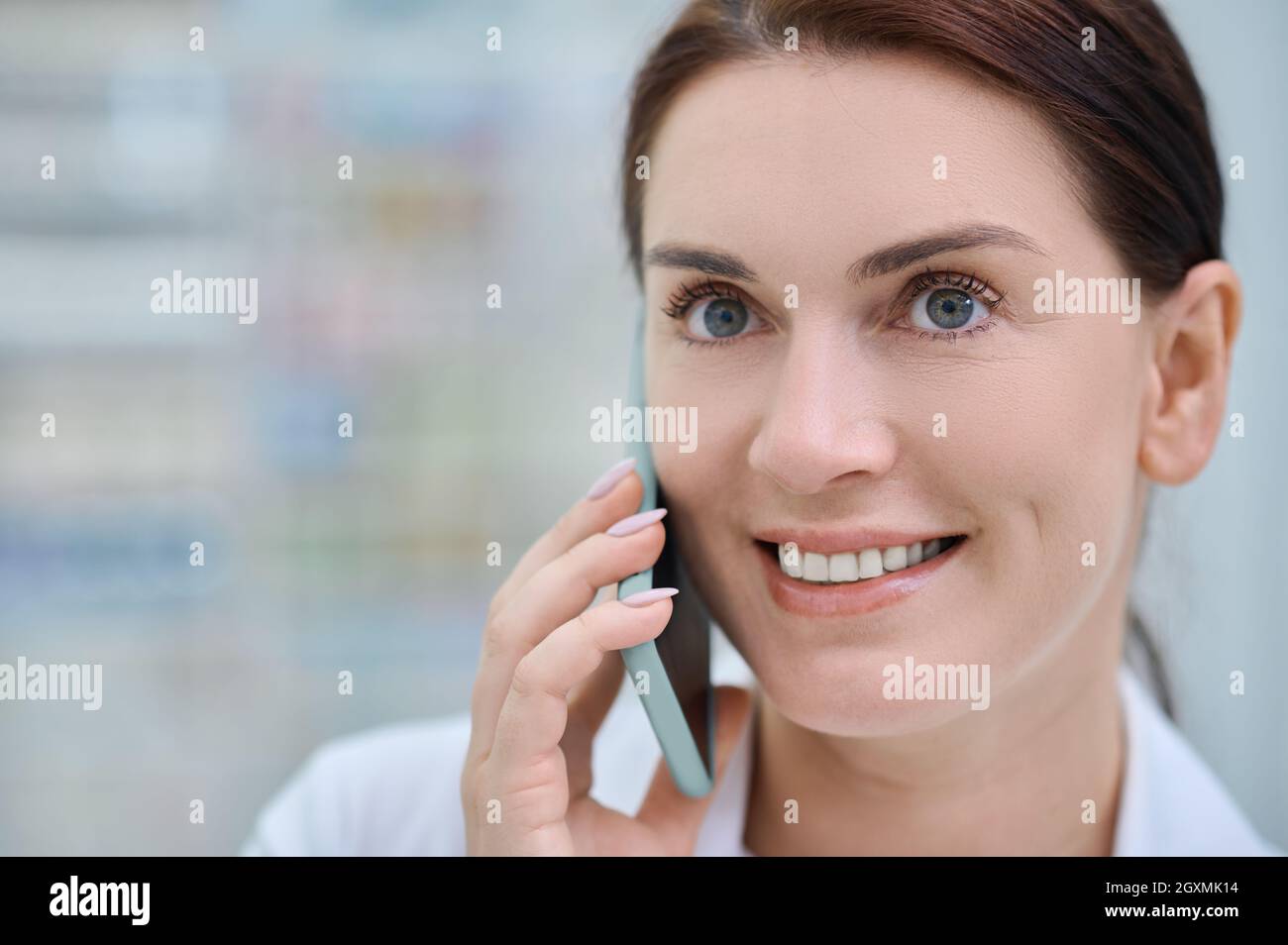 Gros plan sur une femme joyeuse avec un smartphone près de l'oreille Banque D'Images