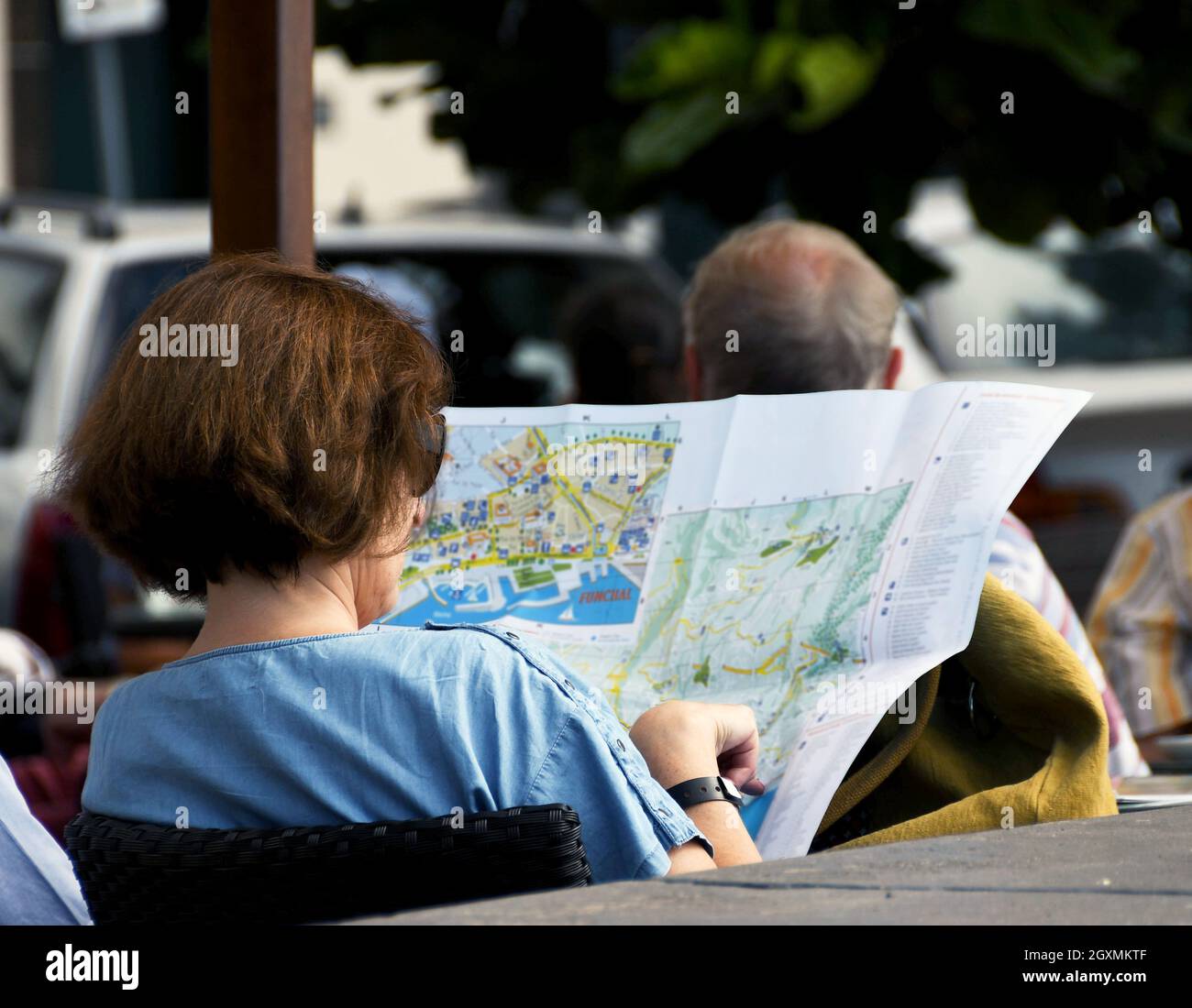 Funchal, Madère, Portugal - février 2016 : personne assise à l'extérieur d'un café lisant une carte de la ville Banque D'Images