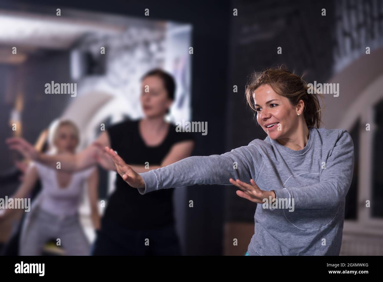 Groupe de jeunes femmes sportive saine s'entraîner avec des exercices d'aérobic faisant de l'instructeur dans une salle de remise en forme, fitness, sport, formation de sport et lifesty Banque D'Images