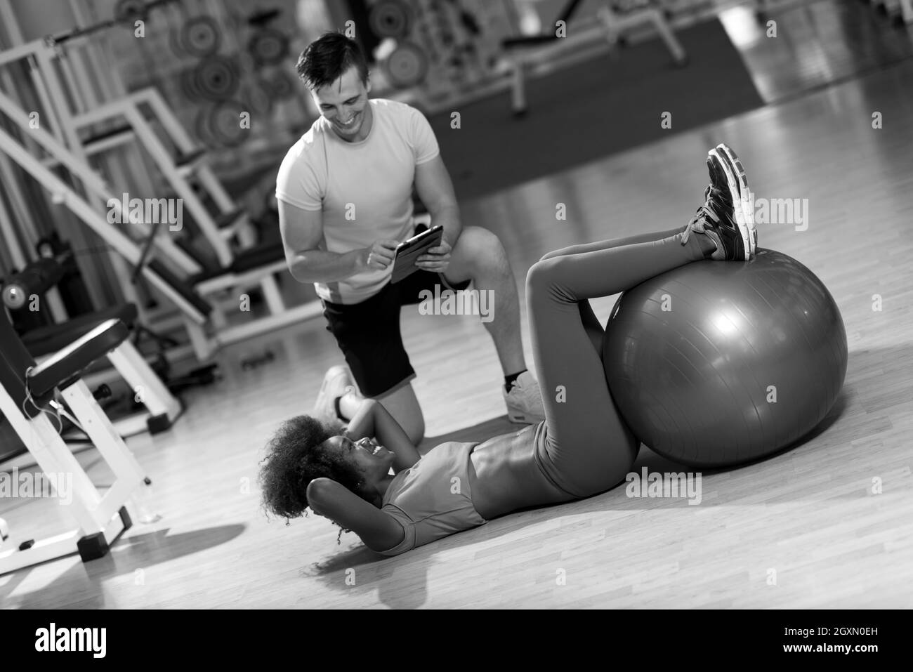 Jeune couple en bonne santé dans l'exercice d'entraînement pilates salle de sport avec un entraîneur personnel Banque D'Images