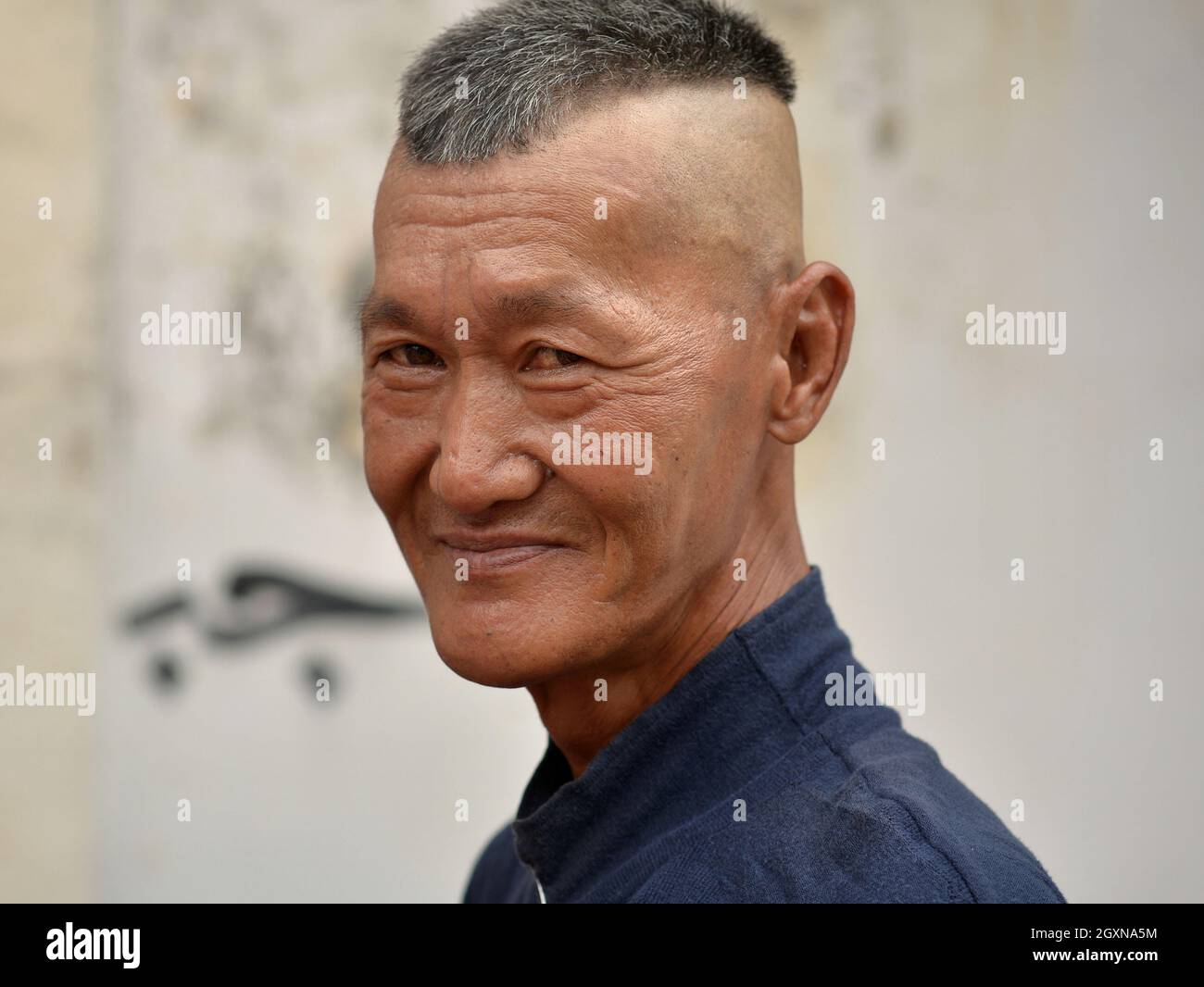 Conducteur traditionnel malaisien de trishaw vieux avec poses de coiffure de contre-dépouille moderne pour la caméra. Banque D'Images