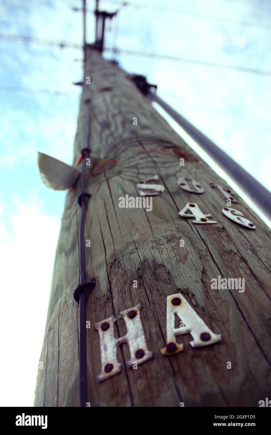 Grand poteau téléphonique avec lettres HA foré dans son côté s'étend vers le ciel Banque D'Images