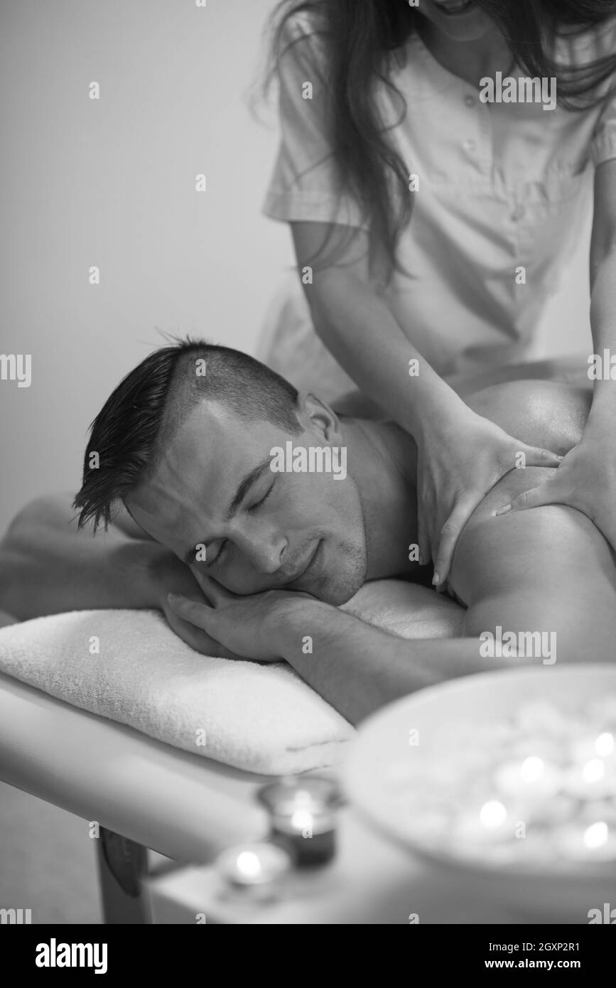 Jeune homme positif d'avoir un massage du dos dans un centre de spa Banque D'Images