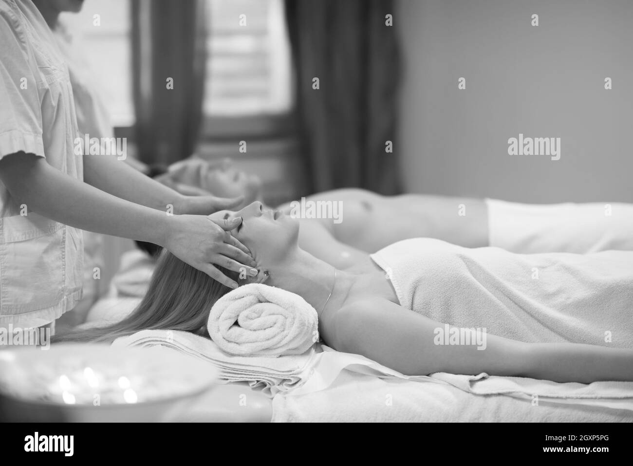 Happy young beautiful couple enjoying head massage au spa Banque D'Images