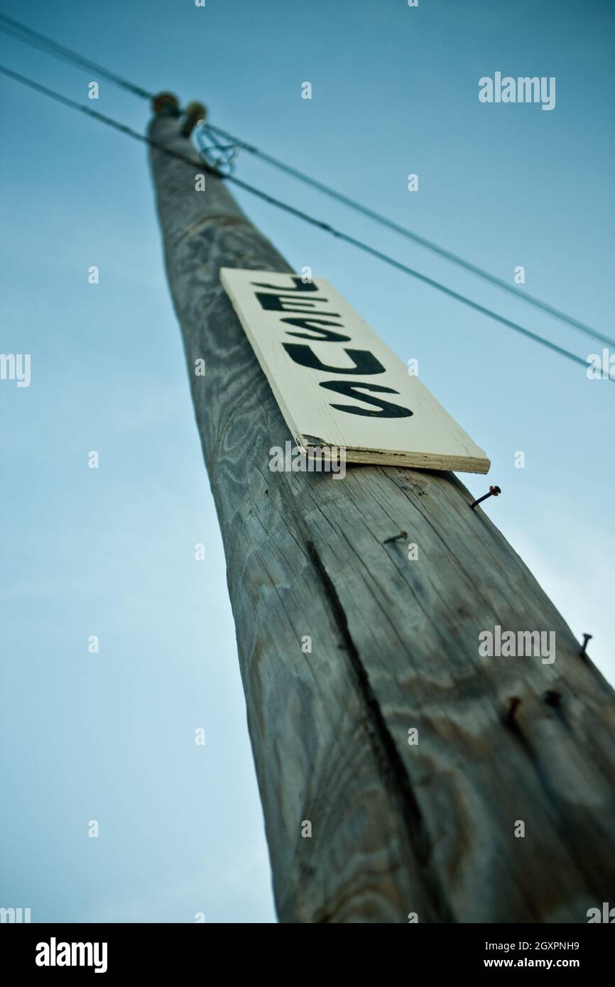 Poteau de téléphone avec des ongles et un signe blanc avec des lettres noires qui lit Jésus Banque D'Images